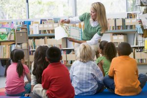 teacher reading book to young children. 50 must read books for pre-k