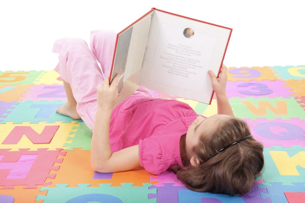 The best way to teach reading - girl lying on floor reading book